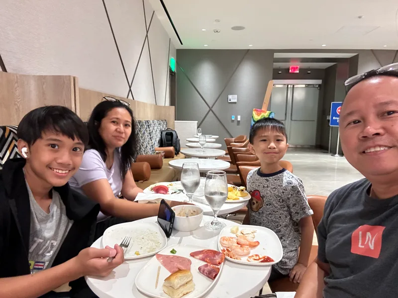Family enjoying a meal at the Delta Sky Club airport lounge