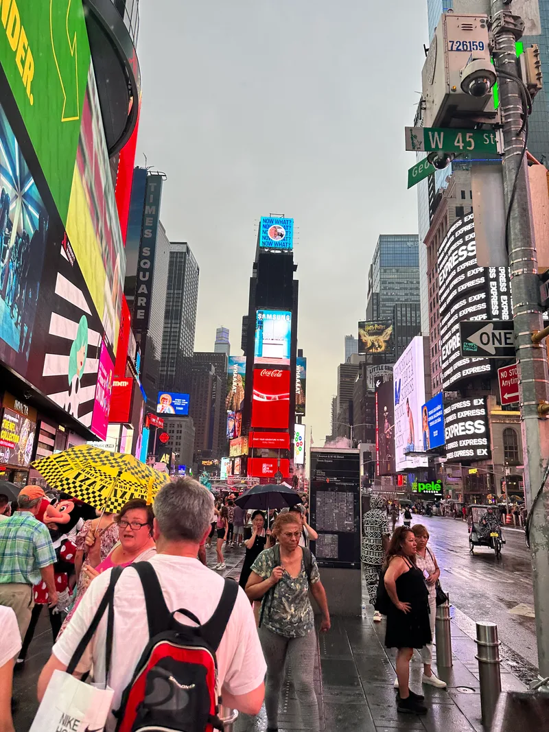 Crowded Times Square street view with bright billboards and people