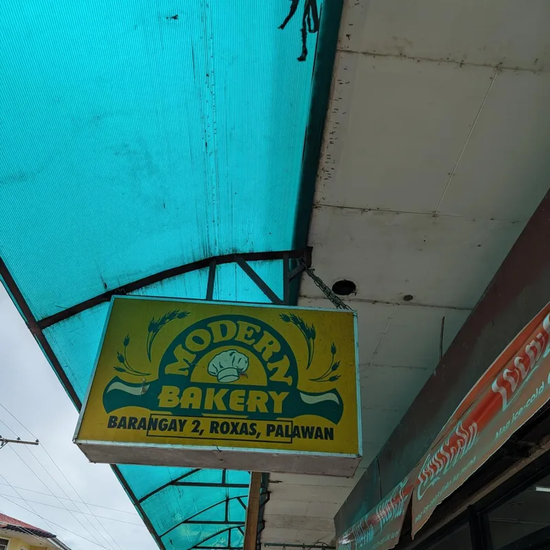 Modern Bakery yellow and blue sign under a blue corrugated awning in Barangay 2 Roxas Palawan Philippines