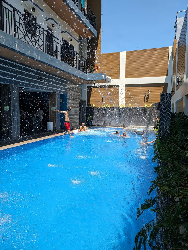 Man jumping into swimming pool at Avery Ridge Resort in Pansol, Calamba, Laguna from a higher edge with water droplets in the foreground.